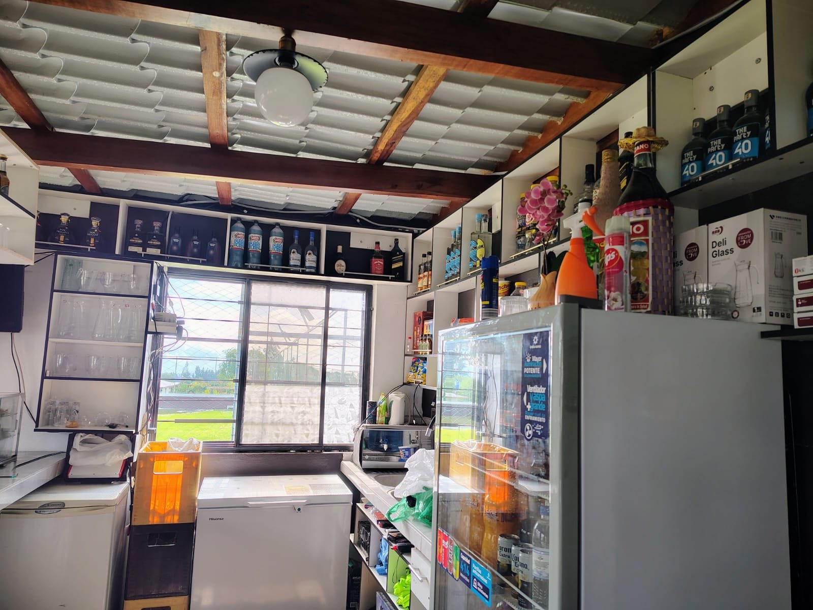 Área de bar o cocina con estanterías y equipos.