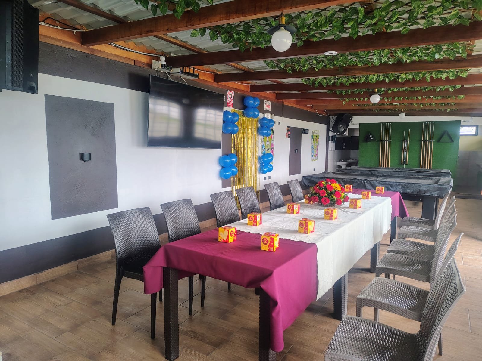 Vista interior de un salón de eventos con mesas preparadas.